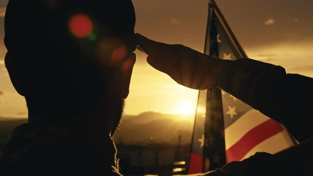 American soldier salutes sunset light