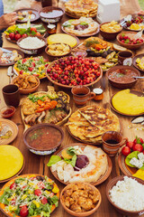Homemade Romanian Food with grilled meat, polenta and vegetables Platter on camping. Romantic traditional moldavian food outside on the wood table.