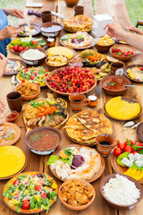 Homemade Romanian Food with grilled meat, polenta and vegetables Platter on camping. Romantic traditional moldavian food outside on the wood table.
