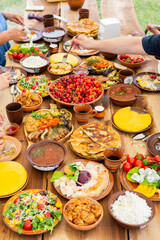 Homemade Romanian Food with grilled meat, polenta and vegetables Platter on camping. Romantic traditional moldavian food outside on the wood table.