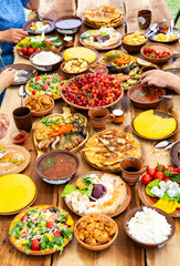 Homemade Romanian Food with grilled meat, polenta and vegetables Platter on camping. Romantic traditional moldavian food outside on the wood table.
