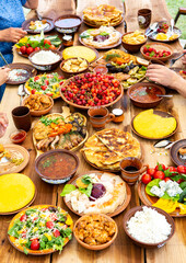 Homemade Romanian Food with grilled meat, polenta and vegetables Platter on camping. Romantic traditional moldavian food outside on the wood table.