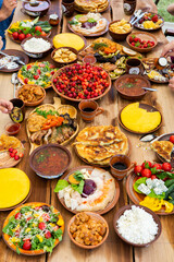 Homemade Romanian Food with grilled meat, polenta and vegetables Platter on camping. Romantic traditional moldavian food outside on the wood table.