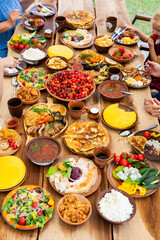 Homemade Romanian Food with grilled meat, polenta and vegetables Platter on camping. Romantic traditional moldavian food outside on the wood table.