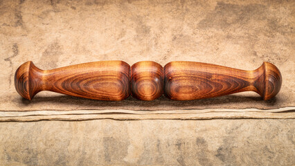 Wooden Tai Chi ruler, a  traditional Chinese exercise tool, on textured bark paper