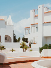 Cozy exterior or patio of the modern building with white walls, arches, windows in summer day.