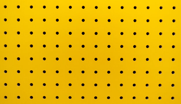 Yellow plastic perforated panel texture. Seamless tile abstract background. Pegboard.