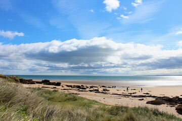 A beautiful view of the sandy coastline along the scottish coastline of Dornoch, in the highlands of Scotland.  It is a sunny day with blue sky.