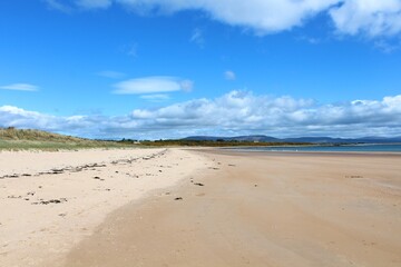 A beautiful view of the sandy coastline along the scottish coastline of Dornoch, in the highlands of Scotland.  It is a sunny day with blue sky.