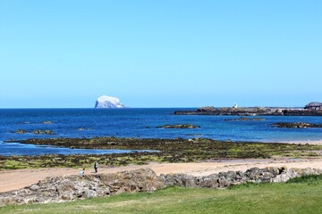 A beautiful view of the sandy coastline along the scottish coastline of North Berwick, East Lothian, Scotland.  It is a sunny day with blue sky