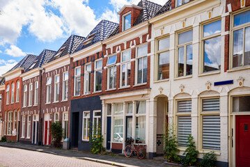 Traditional row houses along a cobbled street on a sunny summer day - obrazy, fototapety, plakaty