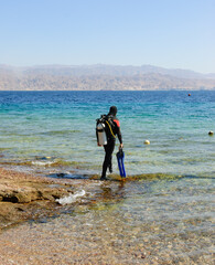 Eilat, Israel. Unidentified (back view) man going to dive. Coral Beach Nature Reserve in Eilat, one...