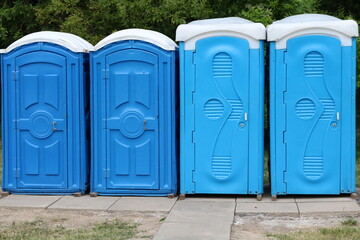photo of several blue toilets on the street