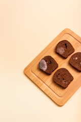 Spoiled rotten moldy rye brown bread on wooden desk from above on light beige background.