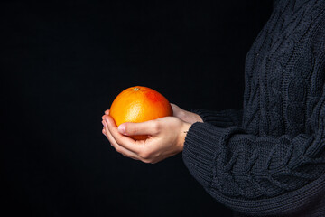 front view hands holding fresh orange on dark background copy place