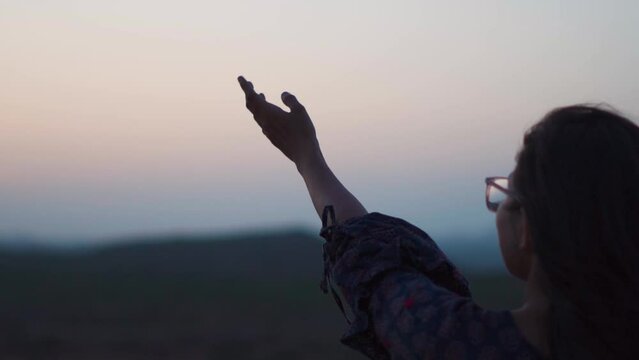 Teenager girl raised her hand towards sky in search of hope. Hopeless girl looking for Hope and Faith.