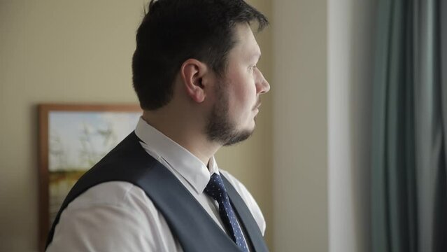 Business man put suit on during morning routine at home, preparing to go to work
