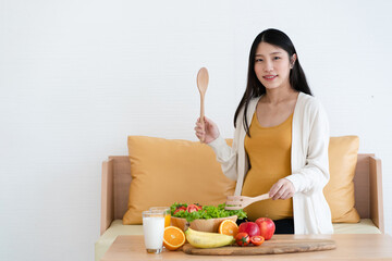 Obraz na płótnie Canvas Asian mothers pregnant are about to eat healthy foods such as fruits, vegetables and milk. Preparing for motherhood requires good health.