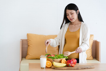 Asian mothers pregnant are about to eat healthy foods such as fruits, vegetables and milk. Preparing for motherhood requires good health.