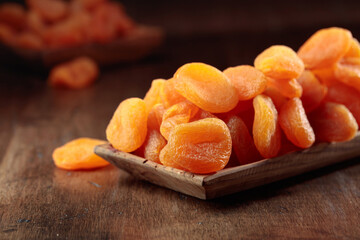 Dried apricots in a wooden dish.