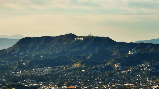 Zoomed footage of hills above city. Radio transmitter and famous Hollywood sign. Los Angeles, California, USA