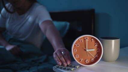 Woman suffering from insomnia at night drinking pills to sleep with water. Insomnia treatment