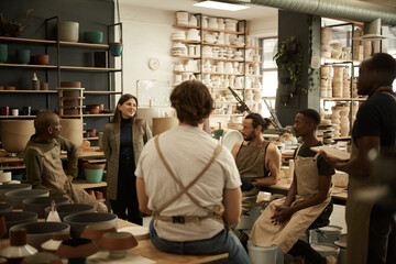 Smiling manager meeting with workers in a ceramics studio - obrazy, fototapety, plakaty