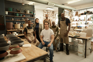 Diverse group of ceramists working in a pottery studio - obrazy, fototapety, plakaty