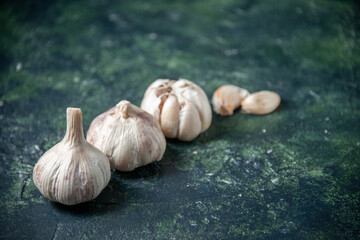 front view fresh garlics lined on a gray background greens plant vegetable sour seasoning food pepper