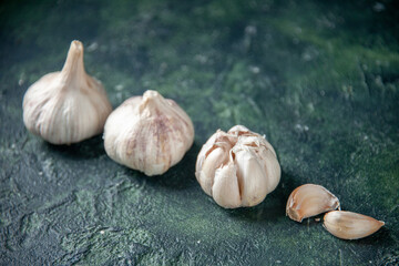 front view fresh garlics lined on gray background greens plant vegetable sour seasoning food pepper