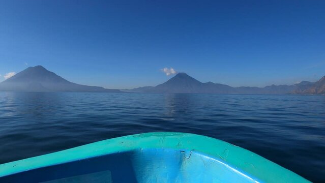 Traveling by boat across Lake Atitlan with Volcanoes in distance, Guatemala, Central America