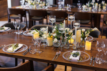 Wedding decorations. Served wedding table with transparent plates, green napkins, decorative fresh white flowers, candles and. Celebration details, wedding outdoor	
