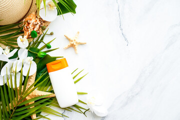 Summer holidays flat lay background. Sun screen products with palm leaves and shells on white. Flat lay with copy space.