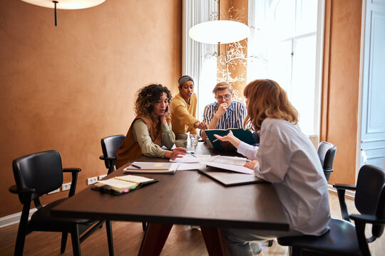 Diverse businesspeople going over paperwork - Powered by Adobe