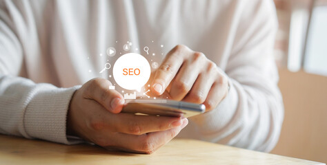 close up man hand use smartphone for search engine optimization (SEO) tools for finding customer or...