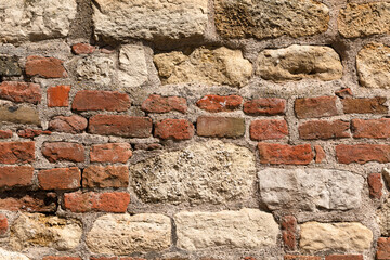 The old wall consists of bricks and stones.
