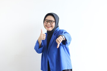 Young beautiful Asian Muslim woman, wearing glasses and blue blazer with angry facial expression