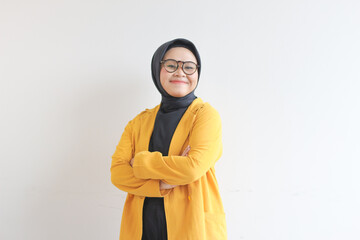 Young beautiful Asian Muslim woman, wearing glasses and yellow blazer with happy smiling face expression