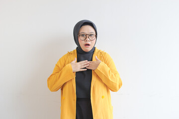 Beautiful young Asian Muslim woman in glasses and smiling putting both hands on chest while shocked expression