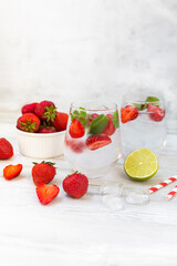 Water with strawberry, mint and lime. Ice cold summer cocktail or lemonade in glass. Detox and diet.