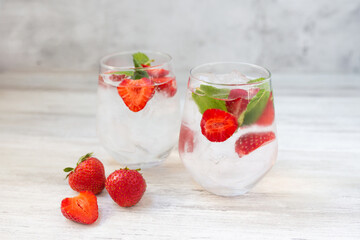 Water with strawberry, mint and lime. Ice cold summer cocktail or lemonade in glass. Detox and diet.