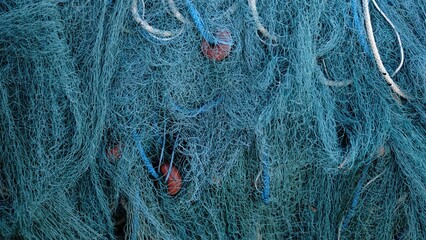 fishing net hanging as a background - obrazy, fototapety, plakaty