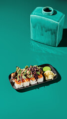 16:9 vertical shot of a luxury sushi roll with salmon tartar and salad mix. Green minimalist backdrop. Perfect for stories on Asian restaurant menu