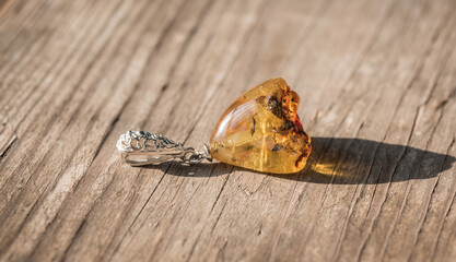 Silver pendant with amber. The stone is cut by hand. The stone can range from yellow and honey to dark burgundy. May include milky streaks and inclusions.