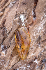Silver pendant with amber. The stone is cut by hand. The stone can range from yellow and honey to dark burgundy. May include milky streaks and inclusions.