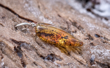Silver pendant with amber. The stone is cut by hand. The stone can range from yellow and honey to dark burgundy. May include milky streaks and inclusions.