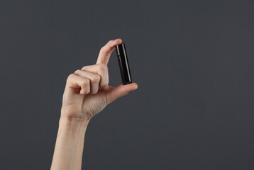 Female hand holding dominoes on a dark gray background