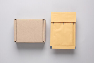 Parcel cardboard box and envelope on gray background. Top view