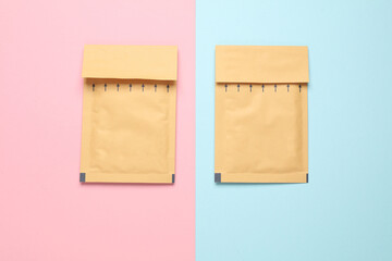 Parcel envelopes on pink blue pastel background. Top view