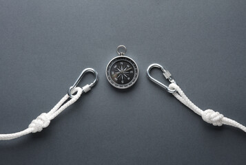Fototapeta na wymiar Carabiners with ropes and compass on dark background. Tourism, mountaineering, outdoor activities